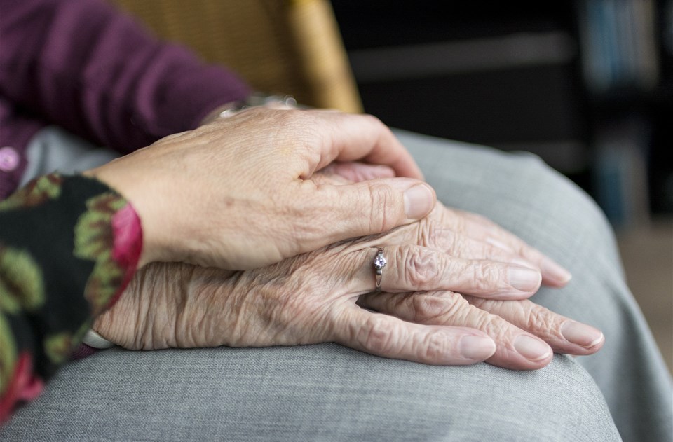 En yngre persons hand som håller i en äldre persons hand